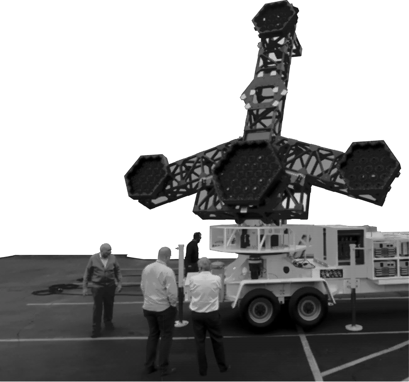 Team members standing beside a large radar array on a mobile platform
